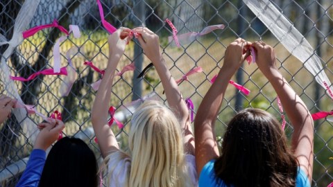 Unos estudiantes ponen listones en el cerco de la primaria Jenny Lind de Valley Springs en honor a Leila Fowler, víctima de asesinato.