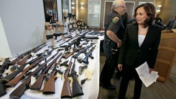 Armas incautadas a personas que tenían legalmente prohibido poseerlas son mostradas en una conferencia de prensa en Sacramento, California.