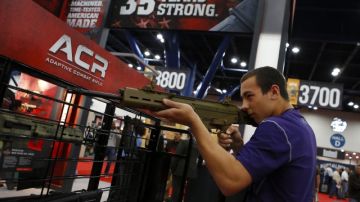 Cade Spikes, de 14 años, prueba una escopeta  durante la convención de la Asociación Nacional del Rifle que inició ayer en el recinto ferial de George R. Brown en Houston, Texas.