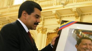 Cristina Fernández (d), recibiendo una fotografía del fallecido presidente Hugo Chávez, de su par venezolano, Nicolás Maduro (i).