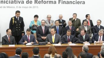 El presidente mexicano, Enrique Peña Nieto (2-izq.), acompañado por los líderes de las principales fuerzas políticas del país, firma el documento de una reforma al sector financiero, ayer.