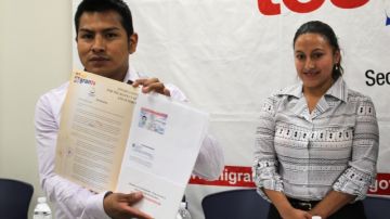 El  ecuatoriano Fausto Plaza muestra sus documentos de  residencia enfrente de su esposa, Tania Loja,  en Queens, Nueva York.