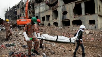 Los rescatistas cargan en camilla a una de las víctimas del mortal incendio. Entre los muertos están  el director gerente de la fábrica y director de la  Asociación Bengalí de Fabricantes y Exportadores.
