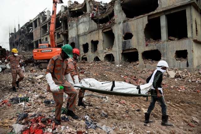 Los rescatistas cargan en camilla a una de las víctimas del mortal incendio. Entre los muertos están  el director gerente de la fábrica y director de la  Asociación Bengalí de Fabricantes y Exportadores.
