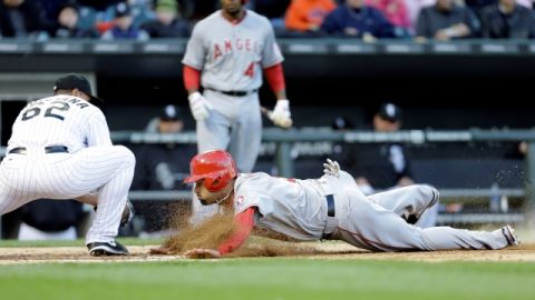 Albert Pujols se lanza de cabeza para llegar a home  y anotar tras un error del receptor Tyler Flowers.