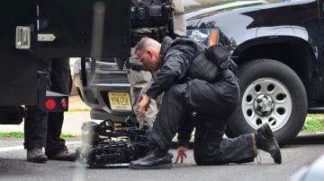 Un miembro del equipo Swat de la Policía estatal alista a un robot para entrar en una casa, donde un hombre tiene a varios menores como rehenes, en New Jersey, ayer.