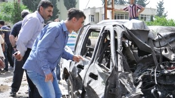 Gente curiosa se acerfca para ver los vehículos que hicieron explosión causando gran destrucción y muerte.