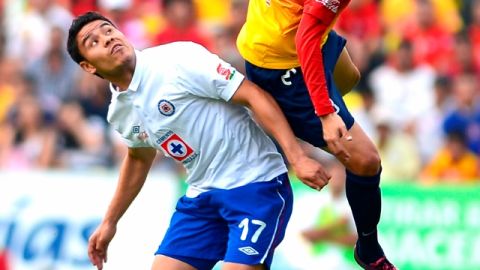 Pablo Barrera realiza una carga sobre Carlos Morales para evitar que gane el balón por alto.
