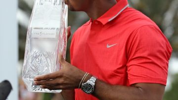 Tiger Woods besa su trofeo después de ganar ayer el Campeonato The Players en el TPC Sawgrass, en Ponte Vedra Beach, Florida.