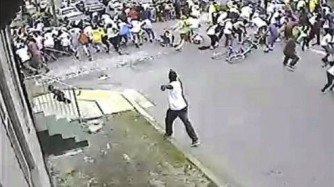 Imagen tomada de un video de una cámara de vigilancia que muestra la escena de la multitud dispersándose mientras un hombre dispara en el desfile por el Día de la Madre en Nueva Orleans.