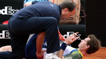 El británico Andy Murray recibe tratamiento de su fisioterapeuta por los problemas de espalda que sufrío en su partido de ayer en Roma.