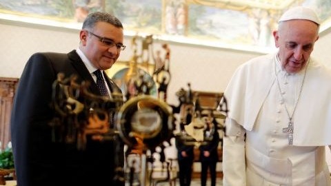 El papa Francisco observa el relicario del arzobispo asesinado Óscar Romero que Mauricio Funes le ha regalado.