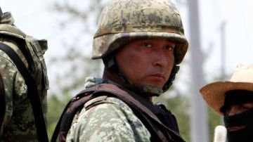 Un soldado junto a un miembro de un grupo de autodefensa local en Buenavista, Michoacán, México. Los residentes han tomado las armas para defender su comunidad contra las bandas de narcotraficantes.