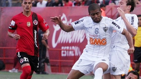 Juan Carlos Núñez, de Xolos, intenta frenar a Junior Machado, del  Mineiro, en duelo de ida de cuartos de final de la Copa Libertadores.