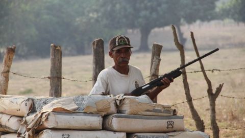 Un guardia de seguridad detrás de un retén de vigilancia entre la carretera que conecta a dos municipios de Florencio Villarreal, estado de Guerrero.