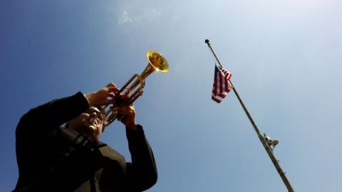 Jesús Montes toca la llamada militar Taps durante la ceremonia en honor a los caídos realizada en Cinco Puntos en el este de Los Ángeles.