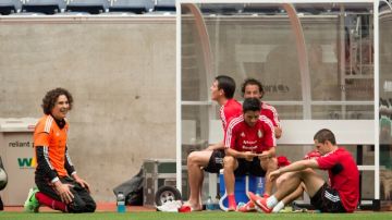 Guillermo Ochoa (izq.) bromea con sus compañeros, mientras que el 'Chicharito' Hernández aparece  pensativo, en un descanso de la selección mexicana en el Estadio Reliant.