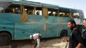 Varios policías egipcios se observan junto a un autobús que sufrió un accidente ayer cerca de la sla del Sinaí, Egipto.