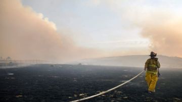Un bombero trabaja en las labores de extinción de un incendio registrado a las afueras de Lancaster, California.