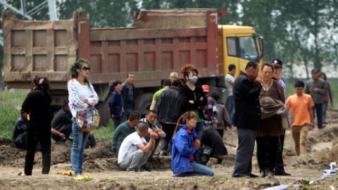 Residentes observan los esfuerzos de rescate en la granja avícola que se quemó y en la cual hay posiblemente más de 120 personas fallecidas, en Jilin, al noreste de China.