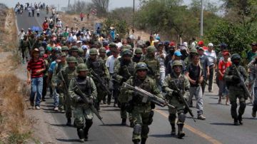 Soldados son acompañados por residentes y miembros armados de un grupo de autodefensa local en la población de Buenavista, en Michoacán