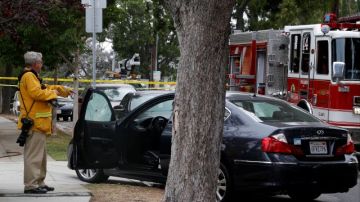 Un investigador verifica el auto donde una mujer fue hallada con una herida de bala, en una zona cercana a la universidad.
