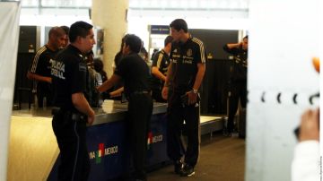 Carlos Salcido (izq.) y 'Maza' Rodríguez (der.) recogen su equipaje en la aduana al llegar la selección a la Ciudad de México.