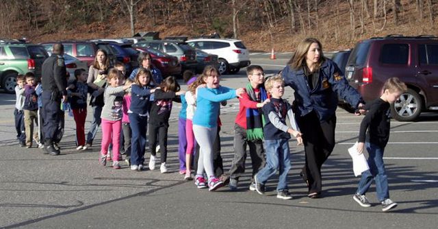 Escolares y maestros huyen de la escuela primaria Sandy Hook, en Newtown, Connecticut, el día en que se reportó la masacre.