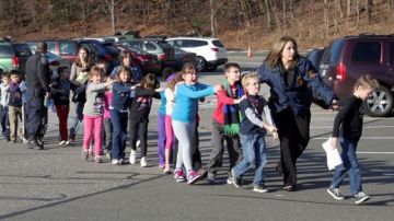 Escolares y maestros huyen de la escuela primaria Sandy Hook, en Newtown, Connecticut, el día en que se reportó la masacre.