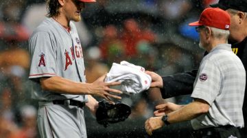 Jered Weaver recibe una toalla para secarse las manos mojadas por la lluvia en la cuarta entrada del juego de ayer ante los Orioles.
