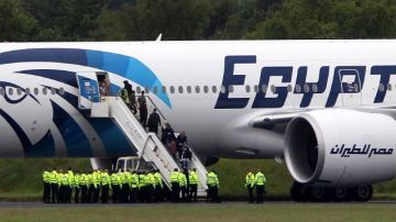 Los pasajeros se bajan de un avión de Egyptair en el aeropuerto de Prestwick, Escocia, después de que lo desviaron cuando se dirigía de El Cairo a Nueva York, el sábado 15 de junio de 2013.