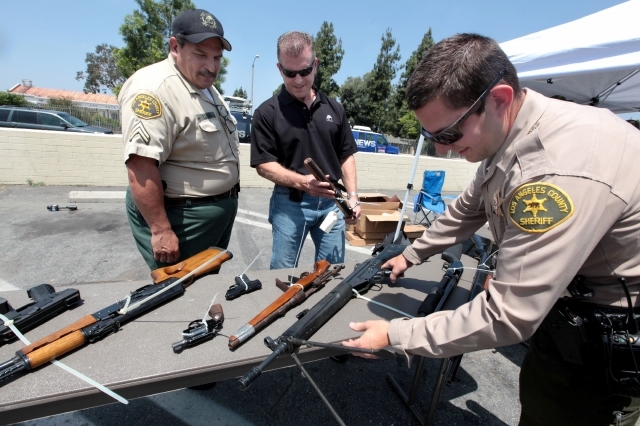 Los agentes del  Sheriff de Los Ángeles revisaban  cada arma que recibían antes de entregar la tarjeta de regalo.