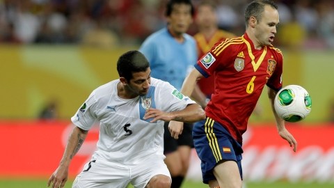 Andrés Iniesta (der.) de España y Walter Gargano, de Uruguay, durante el encuentro de anoche en la Copa Confederaciones que se jugó en Recife, Brasil.