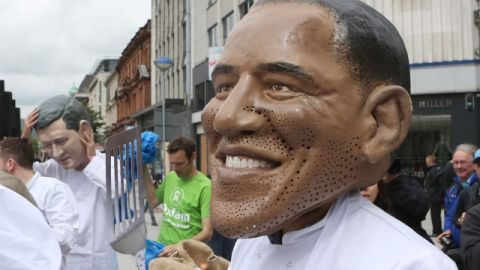 Un activista de Alimentación para Todos viste una máscara de Obama, entre otros que hacen lo mismo con líderes del G8, en Belfast.