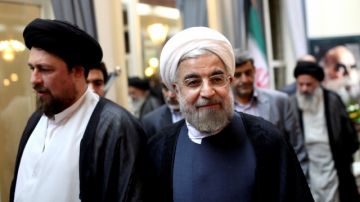El presidente electo iraní Hasan Rohani (der.) es acompañado por Hasan Khomeini, nieto del revolucionario Ayatollah Khomeini.