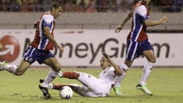 Rolando Escobar cae al intentar frenar al tico  Celso Borges (izq.) en jugada de ayer en San José.