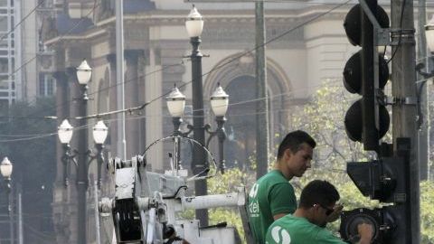 Empleados reparan un semáforo que fue vandalizado en Sao Paulo.