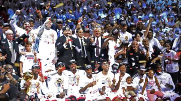Los Heat de Miami posan para una foto tras revalidar el título de campeones de la NBA al vencer 95-88 a los Spurs de San Antonio en el séptimo y decisivo partido de las finales.
