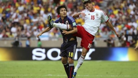 El defensa de México Héctor Moreno (d) pelea un balón con el delantero de Japón Ryoichi Maeda