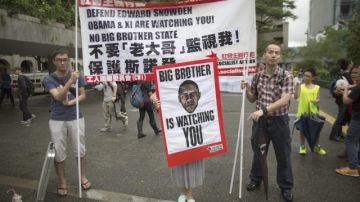 Activistas sostienen carteles en una marcha de protesta a favor de Edward Snowden, frente al Consulado de EEUU, en Hong Kong.