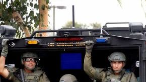 Agentes especializados se despliegan por la zona buscando al sospechoso que se dió a la fuga tras dispararle a dos detectives frente a una estación de policía de Los Ángeles.