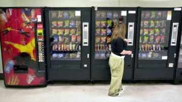 Una estudiante compra  bocadillos en una máquina situada afuera de la cafetería en una escuela de Wichita, Kansas.