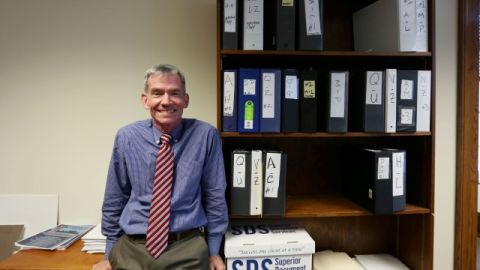 Rich Llewellyn, director del equipo de transición del alcalde electo de Los Ángeles, Eric   Garcetti, posa rodeado de  resumés de personas interesadas en trabajar con el nuevo edil.