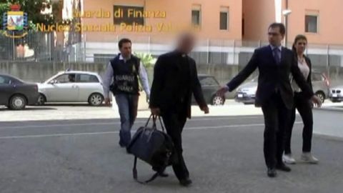 La Guardia Di Finanza (policía fiscal italiana) realiza la detención de un alto prelado del Vaticano (2do. izq.) y a otras dos personas, en Roma, Italia, ayer.