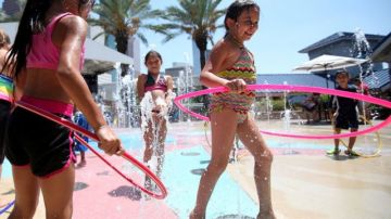 Niños juegan en el agua para refrescarse en el Acuario del centro de Houston, en Texas, donde los termómetros marcaron 103 grados F el sábado en la tarde.