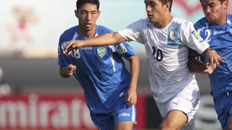 Giorgian De Arrascaeta (10), de Uruguay,  supera a  Sardor Sabirkhodjaev (izq.) y a Tohirjon Shamshitdinov  de Uzbekistán en el duelo de ayer.