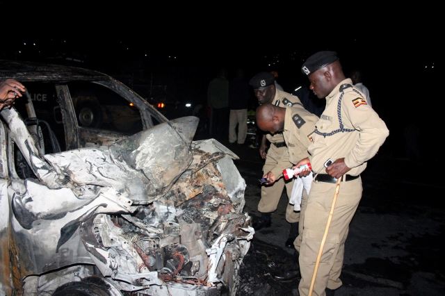 Policía de Uganda inspecciona el auto destrozado que al chocar con un camión de gasolina la explosión mató a 29 personas.