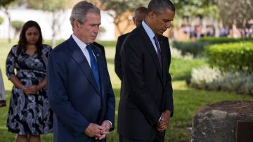 Barack Obama y George W. Bush guardan un minuto de silencio frente a un monumento a los estadounidenses muertos en un ataque contra la embajada de Estados Unidos en Tanzania en 1998.