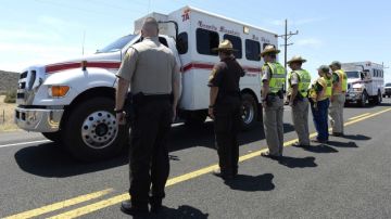 Un grupo de oficiales de la policía de Arizona hace un saludo militar, ayer, ante el desfile de los 19 bomberos que murieron en el fuego.