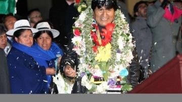 El presidente de Bolivia, Evo Morales (c), es recibido con flores a su llegada al aeropuerto de El Alto en La Paz, Bolivia.